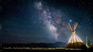 A mesmerizing view of the Milky Way over a teepee under a starry night sky, perfect for astronomy lovers.